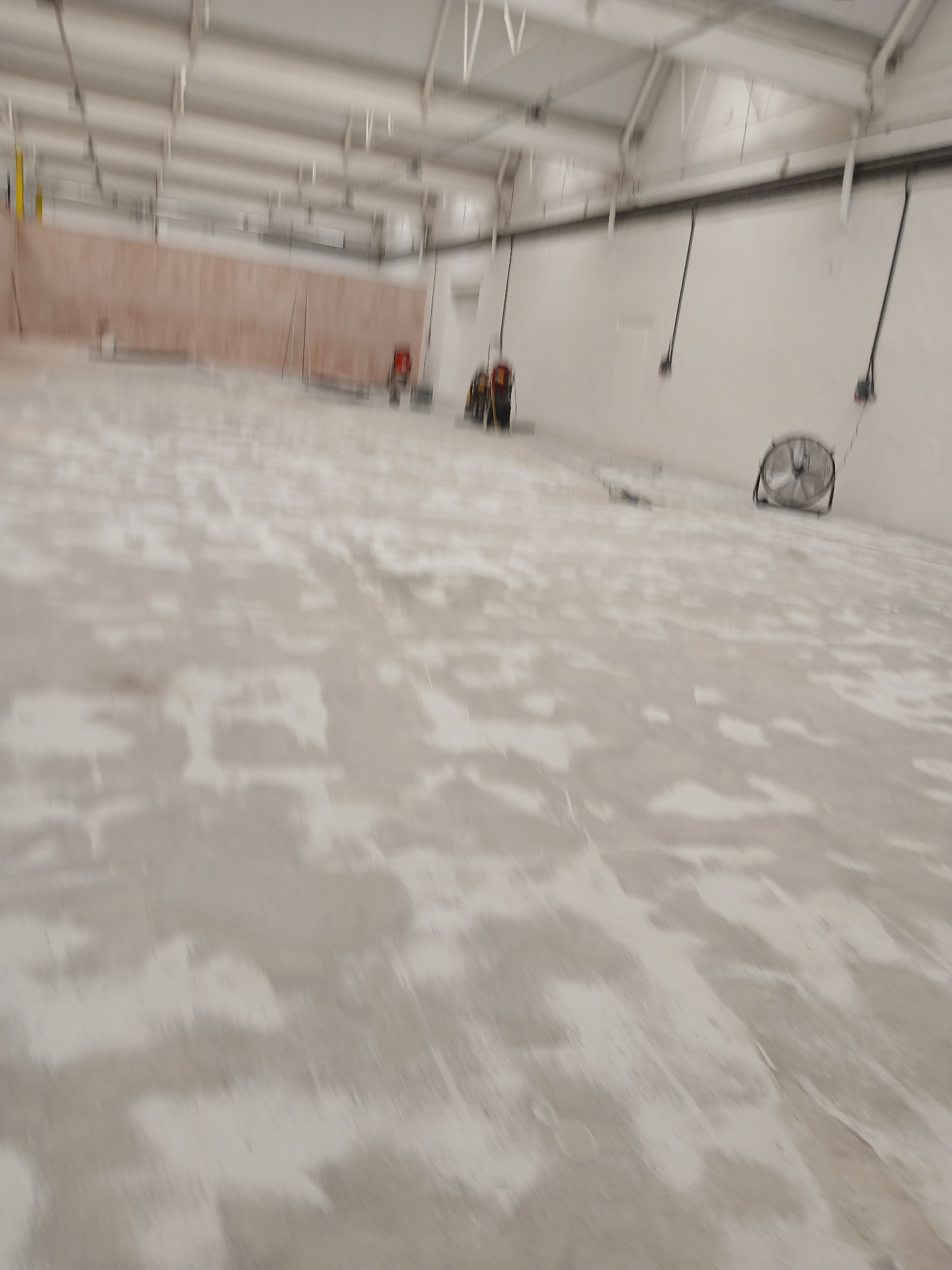 Close-up of contaminated industrial concrete substrate with bitumen and iron-filled areas before epoxy floor preparation in Cumbria